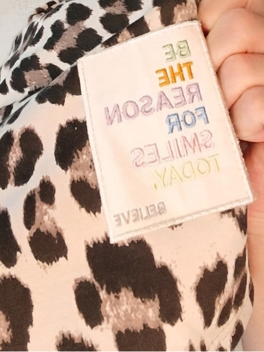 Boho-Luxe Patch auf hellrosa Leopardenmuster-Stoff mit buntem Stickerei-Schriftzug.