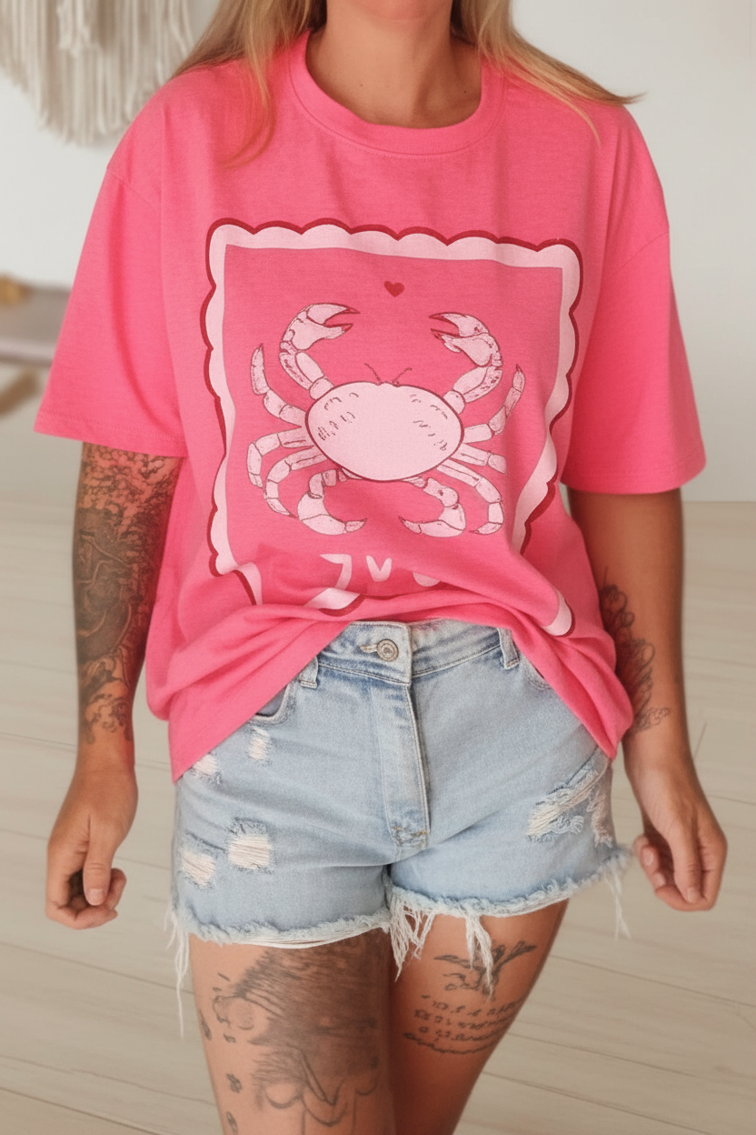 Rosa T-Shirt mit Krebs-Print kombiniert mit hellblauen Jeans-Shorts im Boho-Luxe-Stil.