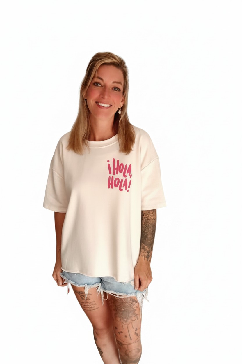Boho-Luxe weißes Oversize-T-Shirt mit rosa Print und hellen Denim-Shorts.