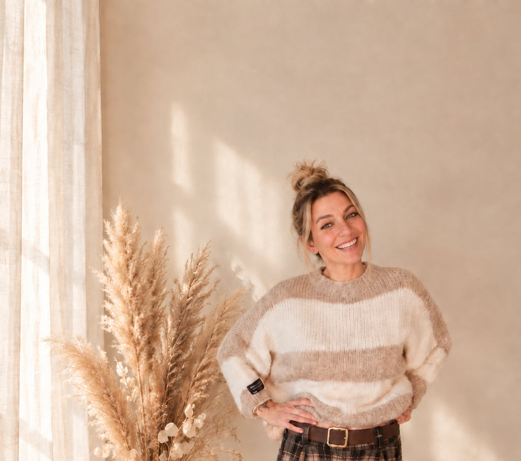 Beige-creme gestreifter Damenpullover mit Rundhalsausschnitt, am Model mit hochgesteckten Haaren und kariertem Rock