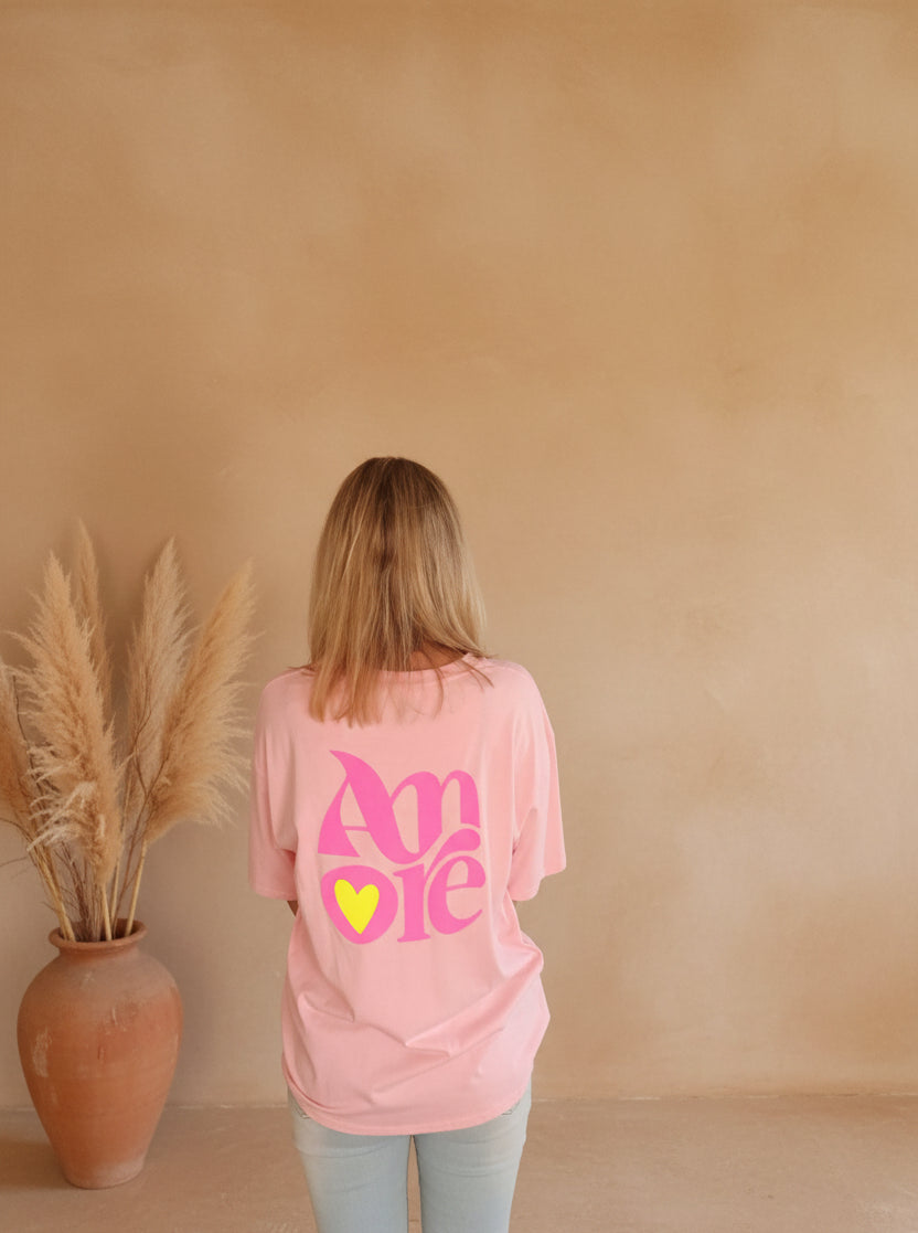 Amore Rosa Oversized T-Shirt rosa – Rückenansicht mit pinkem Amore-Print und gelbem Herz, 100% Baumwolle