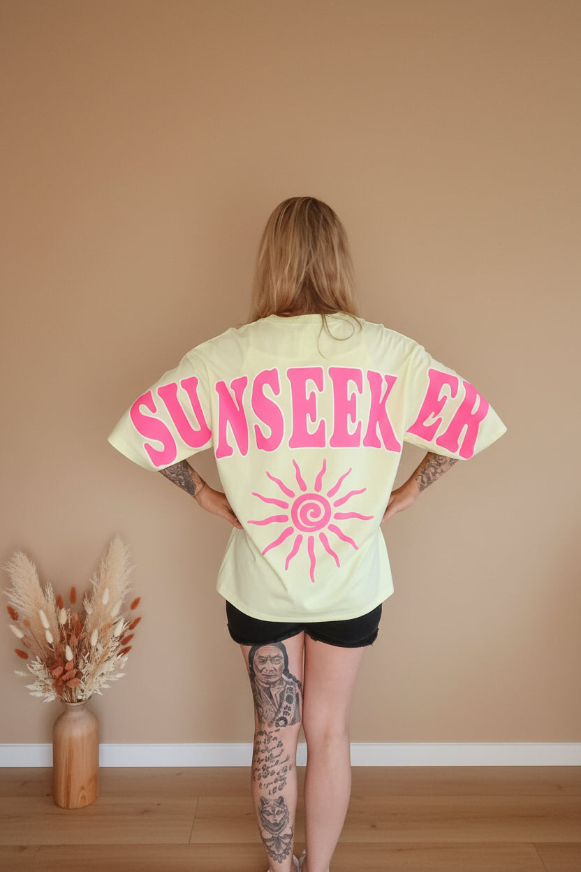 Sunseeker Oversized Shirt – Seitenansicht über Schulter, Rückenprint teilweise sichtbar
