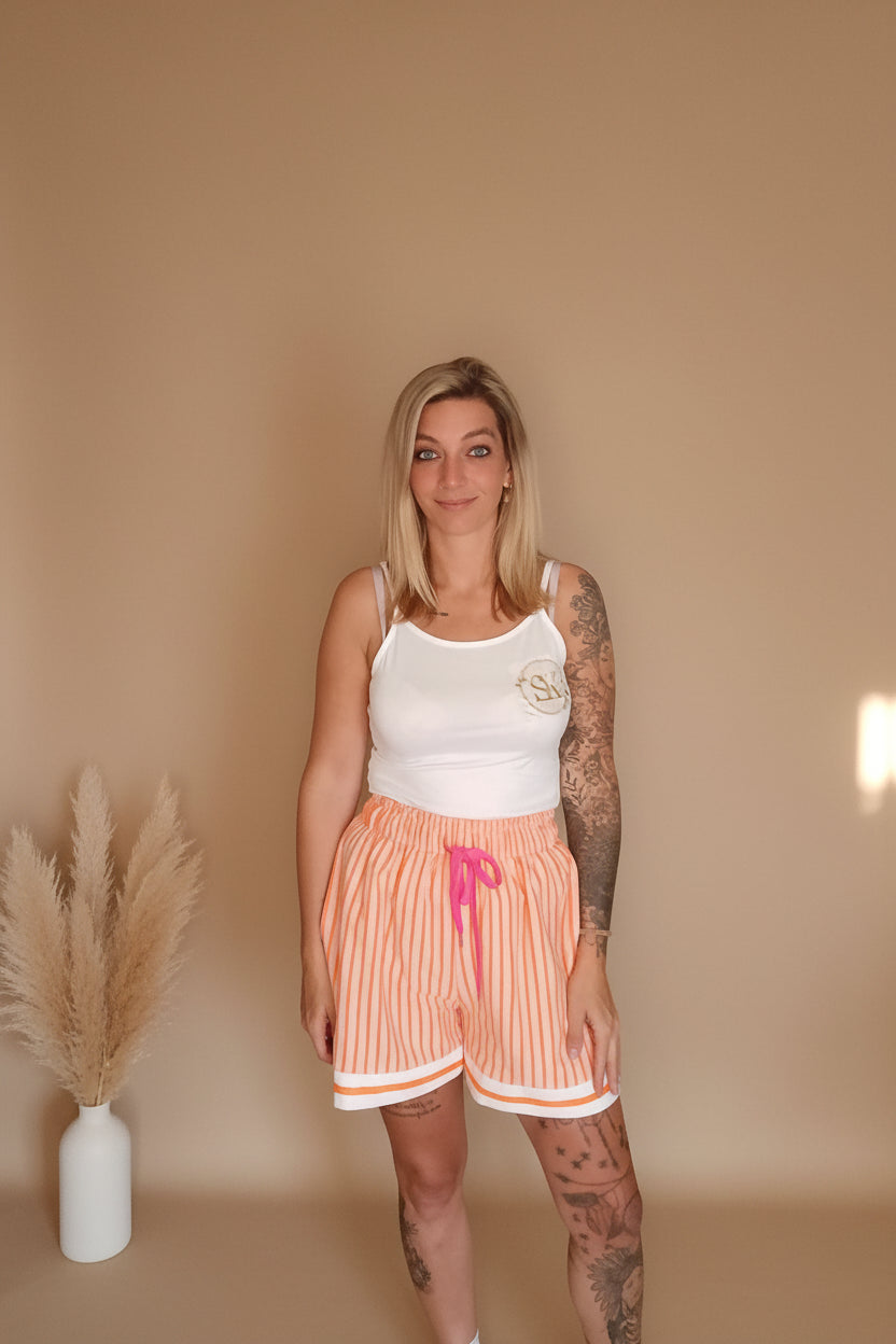 Damen Sommer-Shorts Orange Streifen – Frontansicht, Boho-Wohnzimmer mit Makramee-Wanddeko