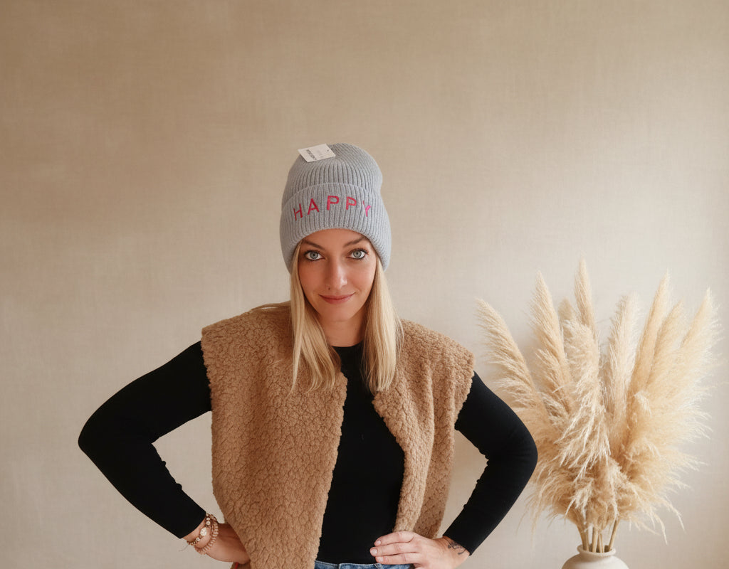 Hellblaue Damen-Beanie mit HAPPY-Schriftzug, Styling-Aufnahme mit schwarzem Oberteil
