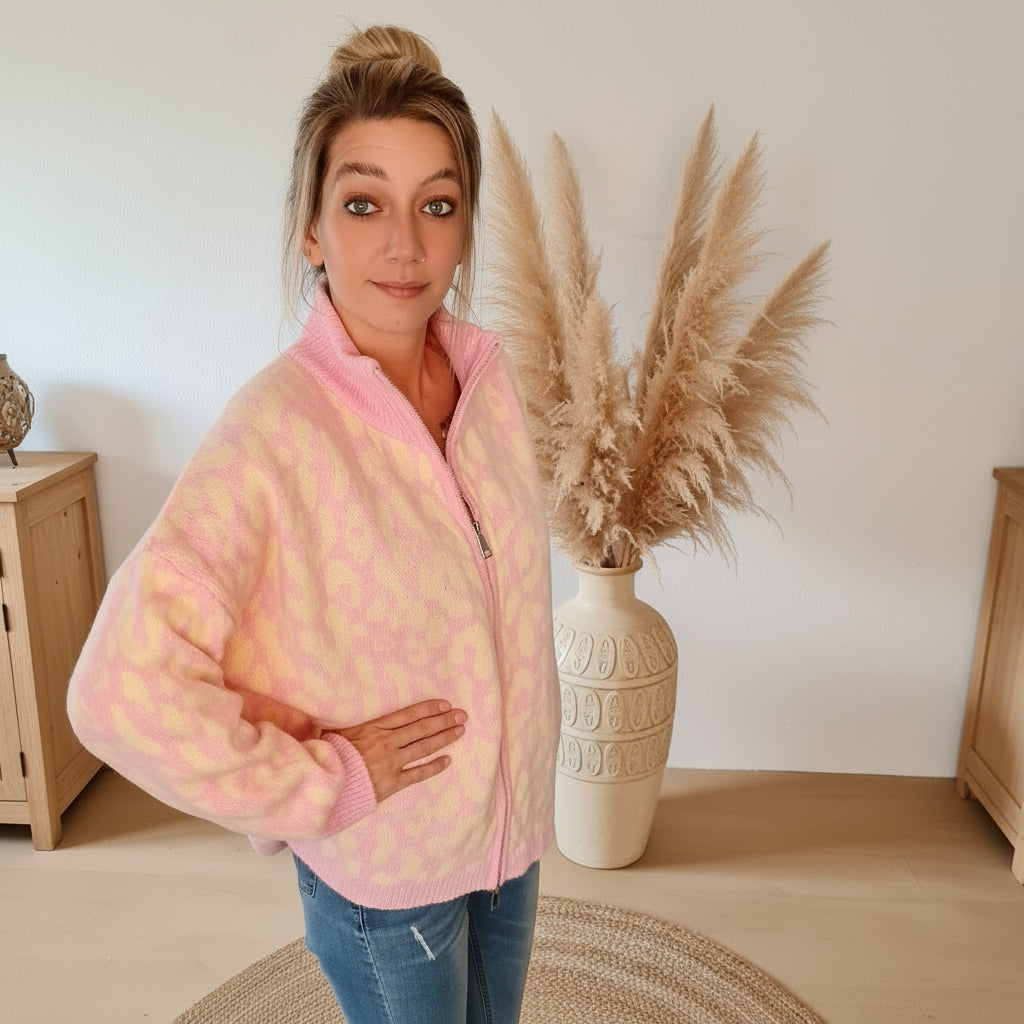 Ganzkörperansicht einer Model in rosafarbener Damen-Strickjacke mit Reißverschluss und Jeans