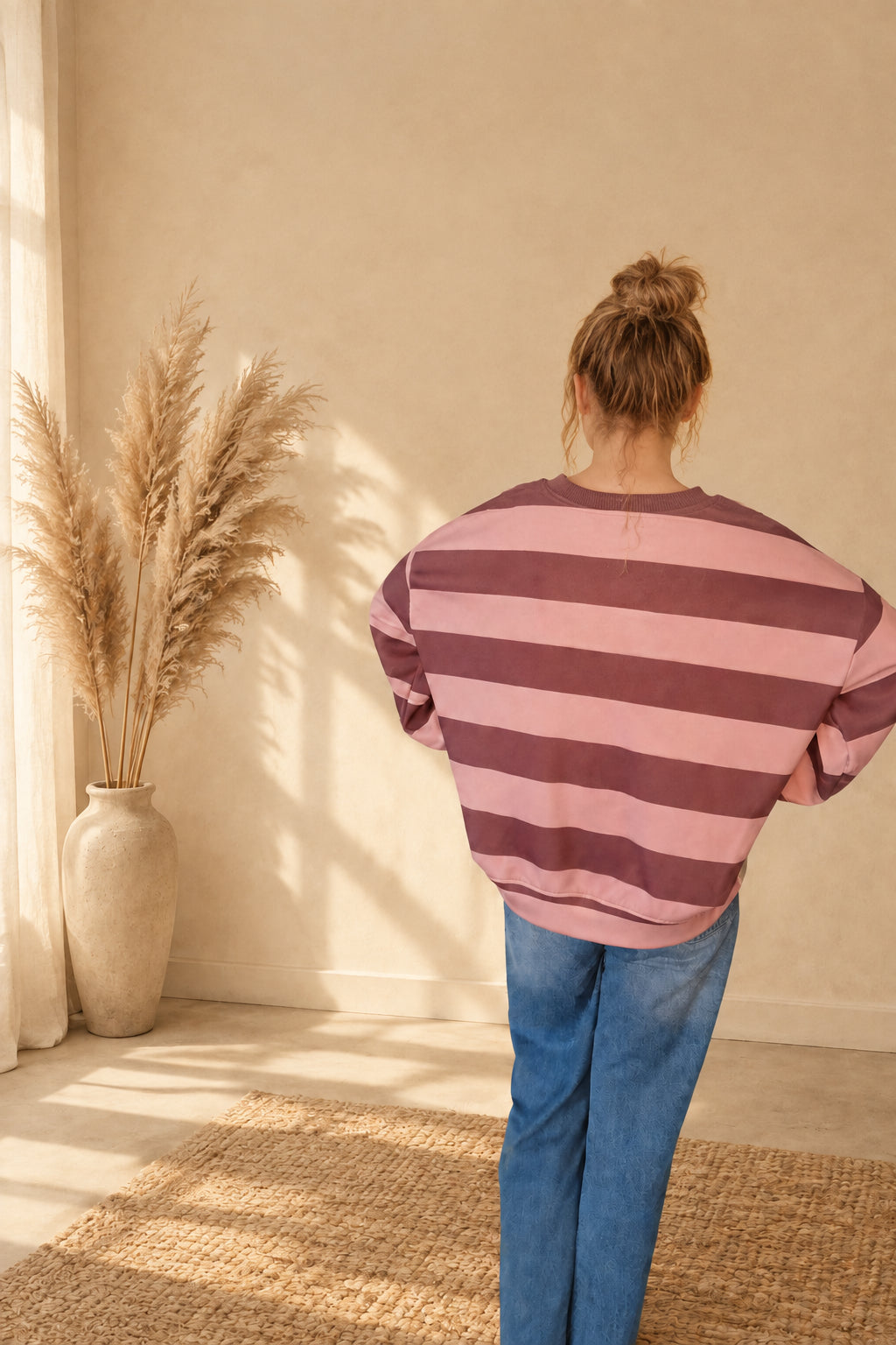 Rückansicht des Damen-Sweatshirts mit breiten Streifen in Rosa und Braun, am Model mit hochgesteckten Haaren.