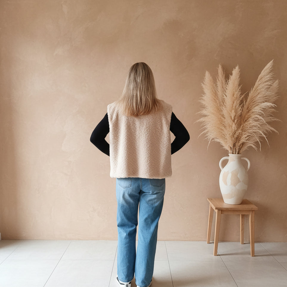 Cremefarbene Teddyweste für Damen in vollständiger Rückansicht, ärmelloses Design und lockere Passform zum Layern