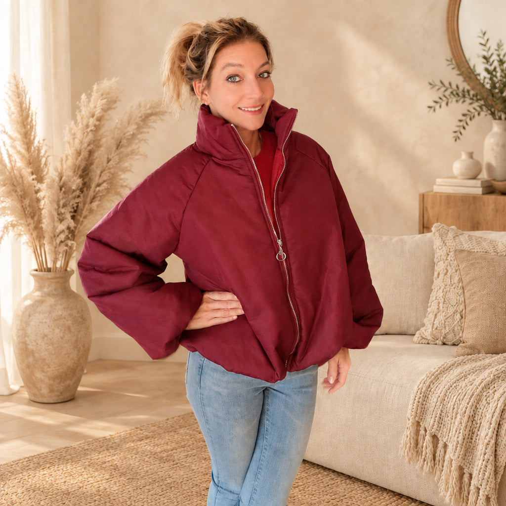 Rote Ballonjacke mit Stehkragen und Reißverschluss, schräg von vorn mit einer Hand an der Hüfte