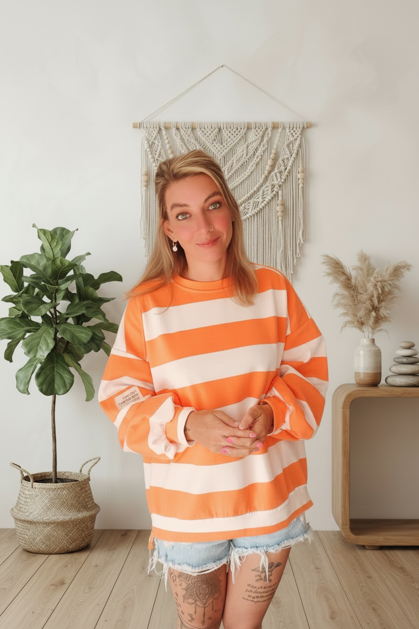 Boho-Luxe gestreiftes Damenoberteil in Orange und Weiß aus weichem Stoff.