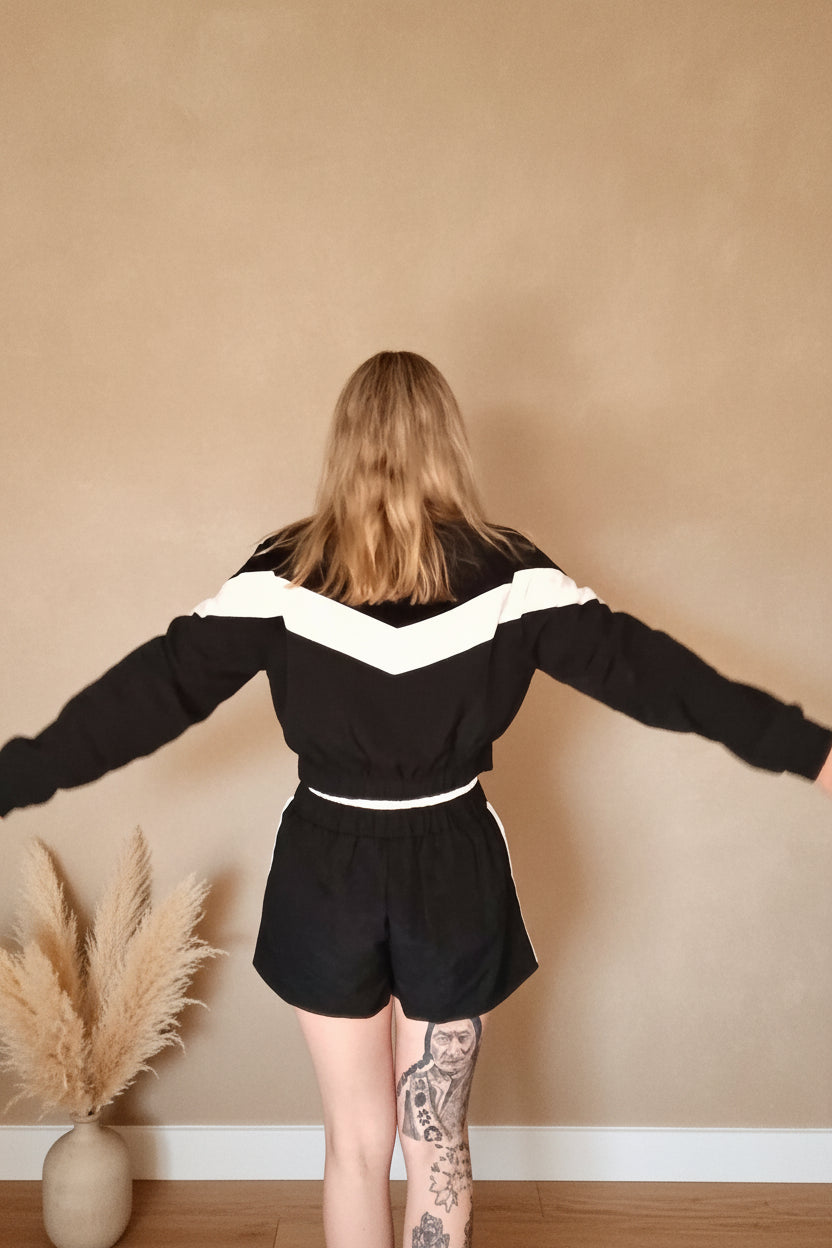 Sportset Damen Rückenansicht – Chevron-Streifen Jacke & Shorts, T-Pose Boho Hintergrund