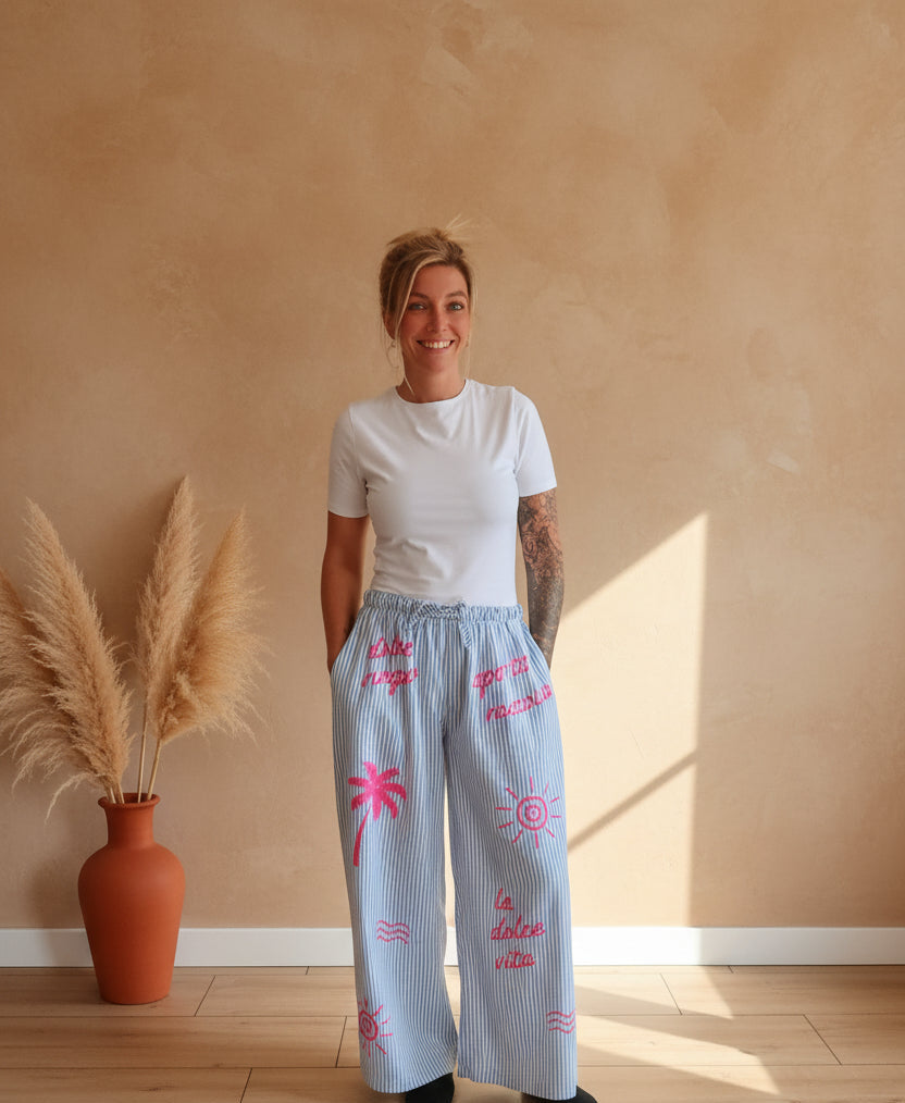 Boho-Luxe hellblaue Leinenhose mit Streifen und pinken Prints für Damen.