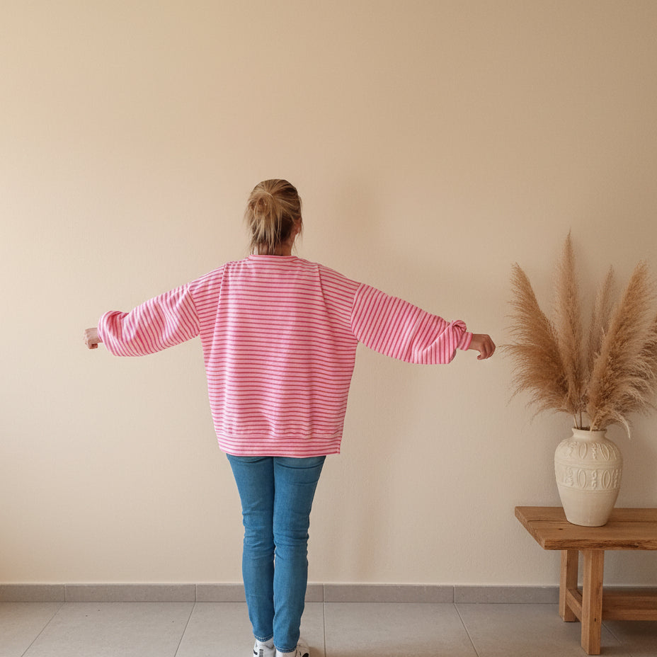 Rückansicht rosaweißes Streifen Sweatshirt Damen mit ausgebreiteten Ärmeln