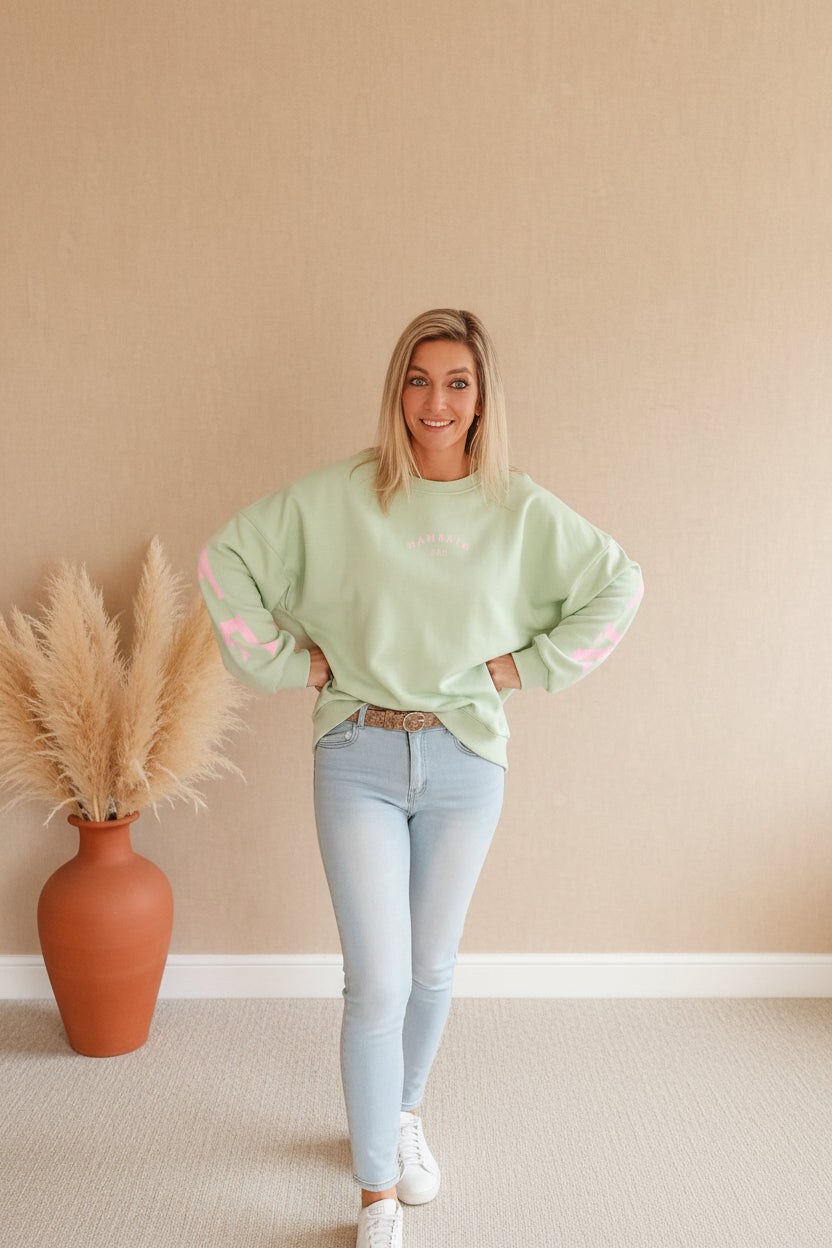 Namaste Sweater Mint Rosa Seitenansicht – Oversized Boho Pullover mit rosa Ärmelschriftzug, kombiniert mit heller Jeans