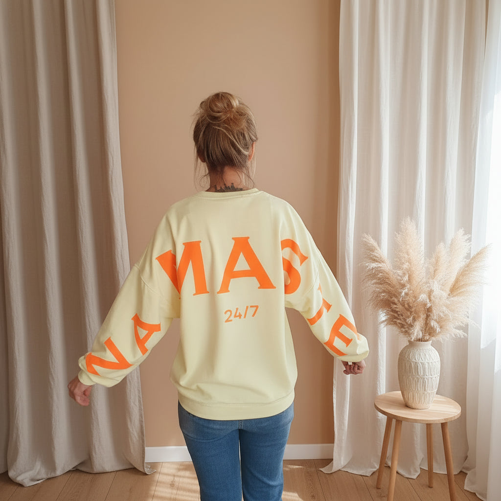 Namasté Oversize Sweatshirt Damen Pastellgelb – Rückenansicht NAMASTE 24/7 Neonorange Großprint und Ärmelprint helle Boho Kulisse