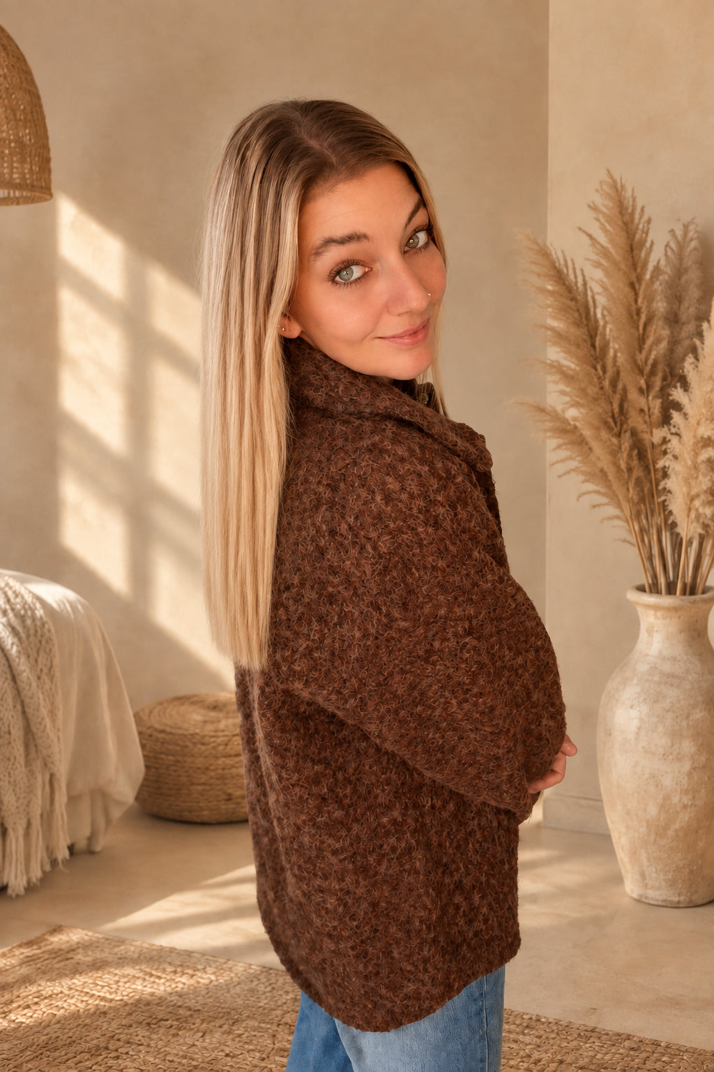Seitliche Rückansicht der braunen Damenjacke mit strukturierter Oberfläche, am Model mit Blick über die Schulter.