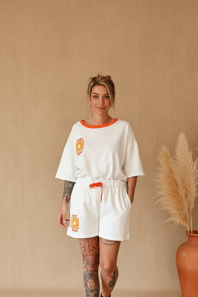 Weißes Boho-Luxe Damen-Set aus Baumwolle mit orangefarbenen Akzenten und Sonnen-Print.
