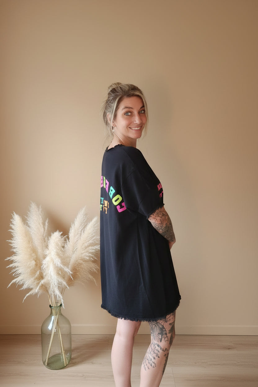 Boho-Luxe Look: Schwarzes Oversize-T-Shirt-Kleid mit farbigem Print aus weichem Stoff.