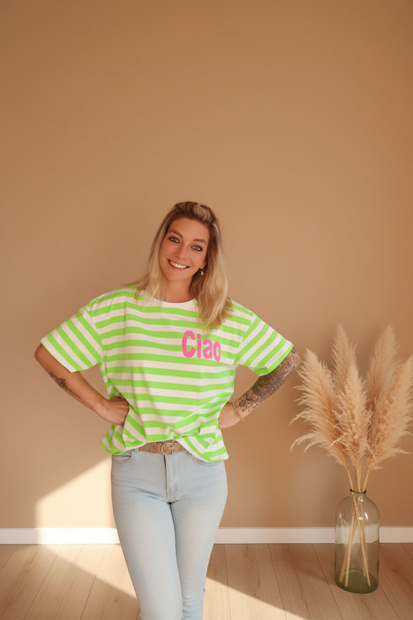 Boho-Luxe Look: Frau in grün-weiß gestreiftem Baumwoll-T-Shirt und hellblauer Jeans.
