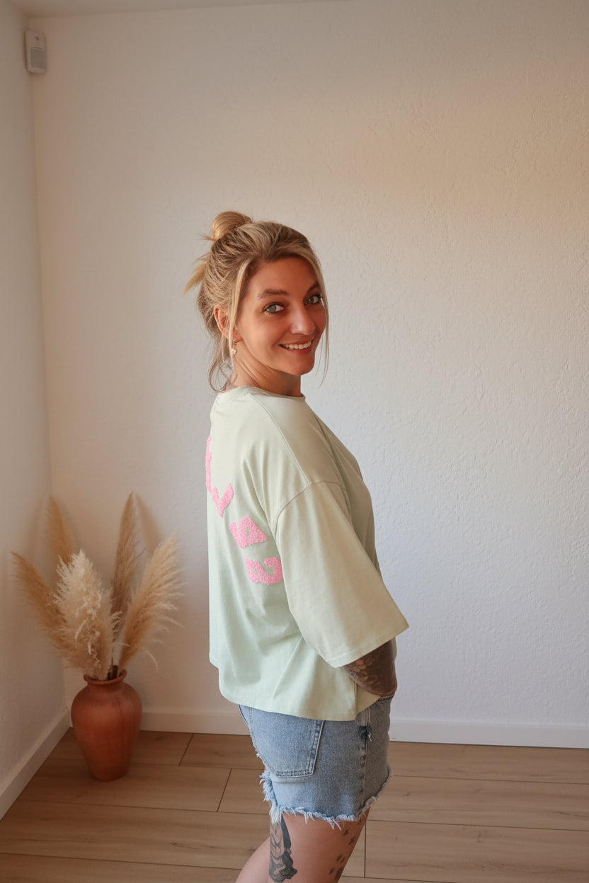 Mintgrünes Oversize T-Shirt Self Love, Seitenansicht mit sichtbarem pinkem Backprint, Boho-Luxe Styling