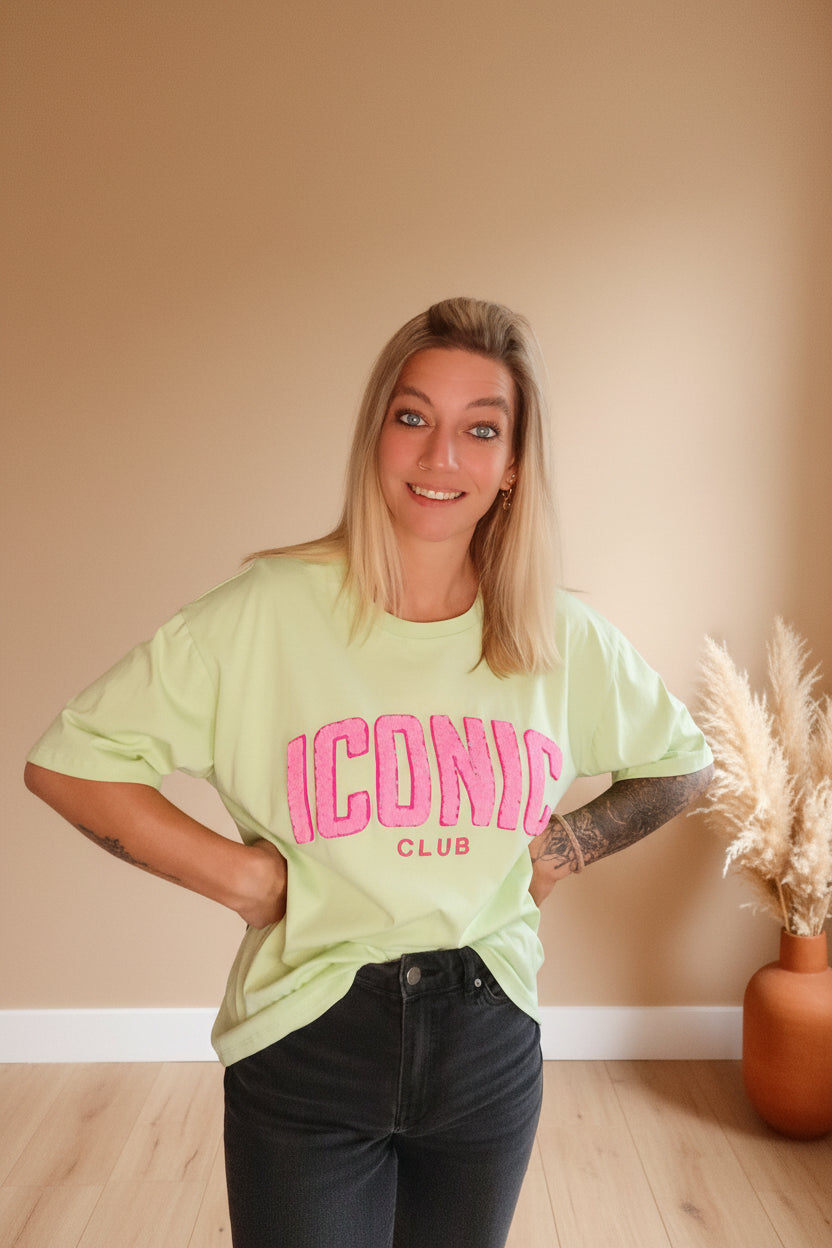 Iconic Club Oversized T-Shirt Soft Lime – Frontansicht lächelnd, Hände in den Hüften