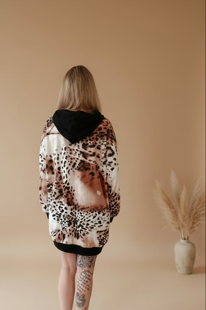 Boho-Luxe Oversize-Hoodie mit Leopardenmuster in Beige und Schwarz aus glänzendem Stoff.