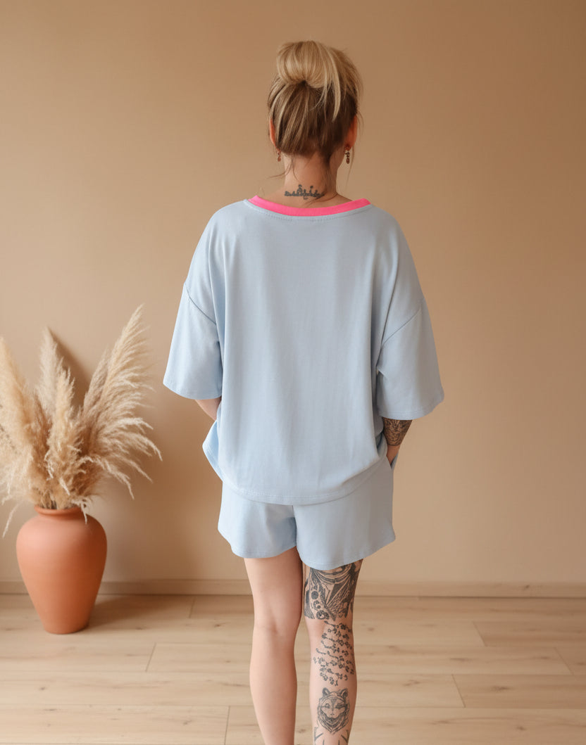 Boho-Luxe hellblaues T-Shirt mit rosa Ausschnitt und passende Shorts aus weichem Stoff.