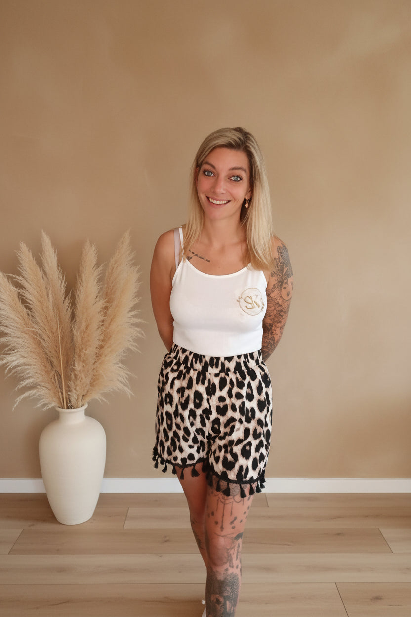 Boho-Luxe Outfit mit weißem Top und Leopardenmuster-Shorts aus weichem Stoff.