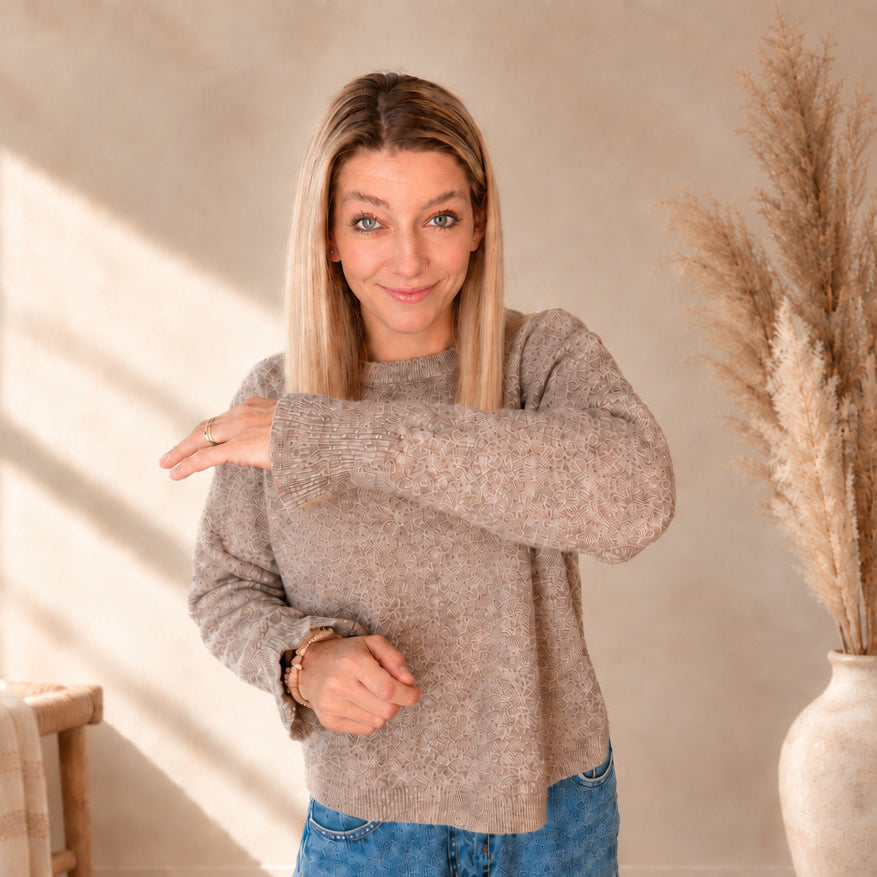 Model zeigt den Ärmel eines taupefarbenen Damenpullovers mit geripptem Abschluss.