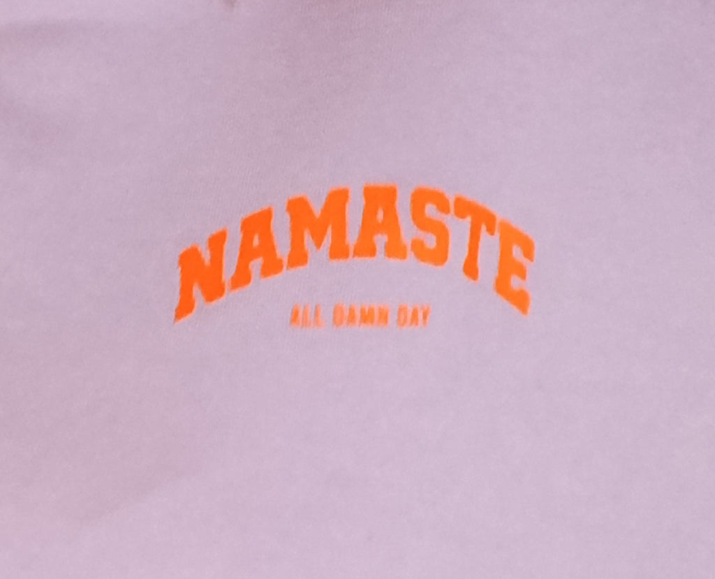 Namaste All Damn Day Print-Detail – orangefarbener Schriftzug auf Lila Sweatshirt