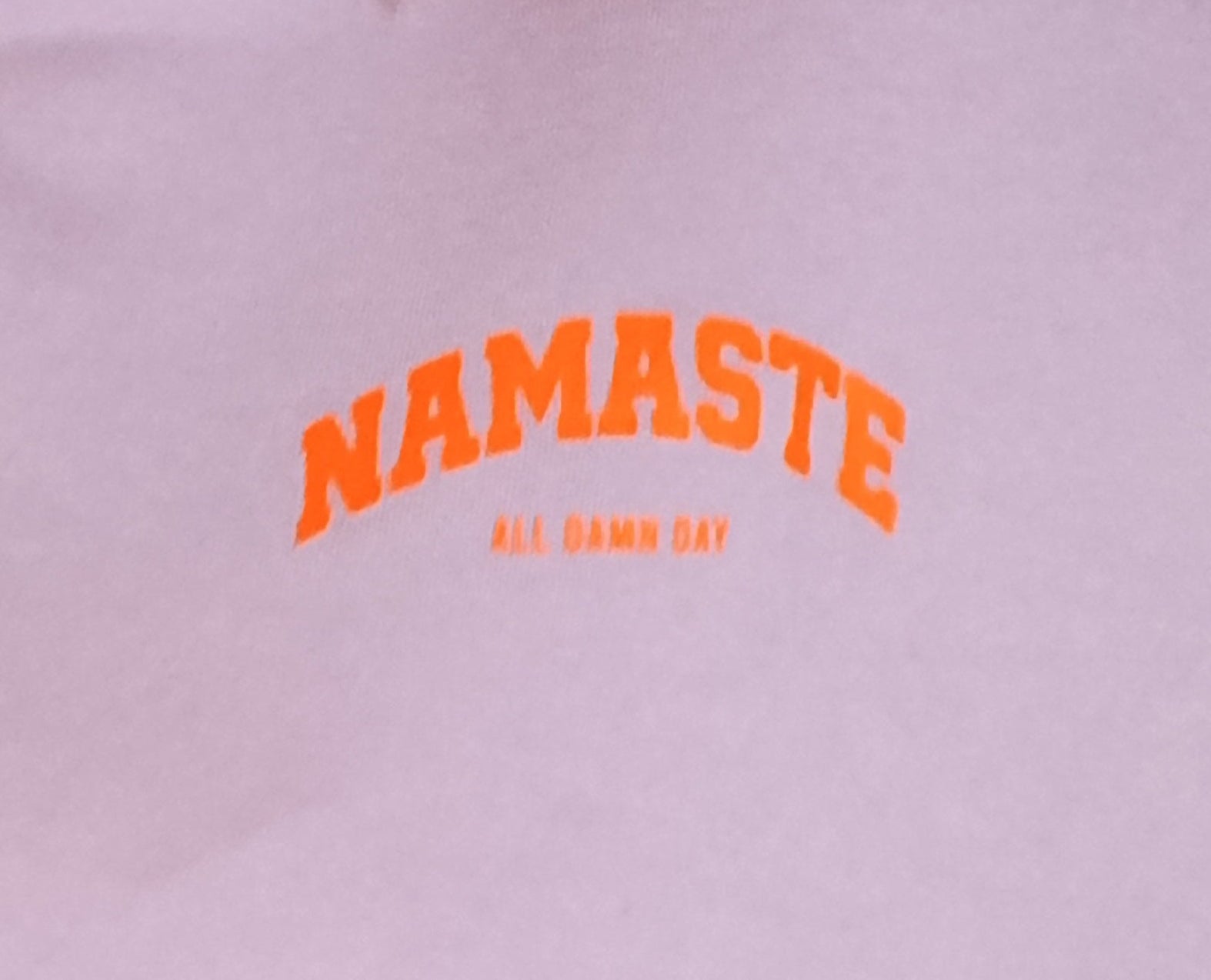 Namaste All Damn Day Print-Detail – orangefarbener Schriftzug auf Lila Sweatshirt