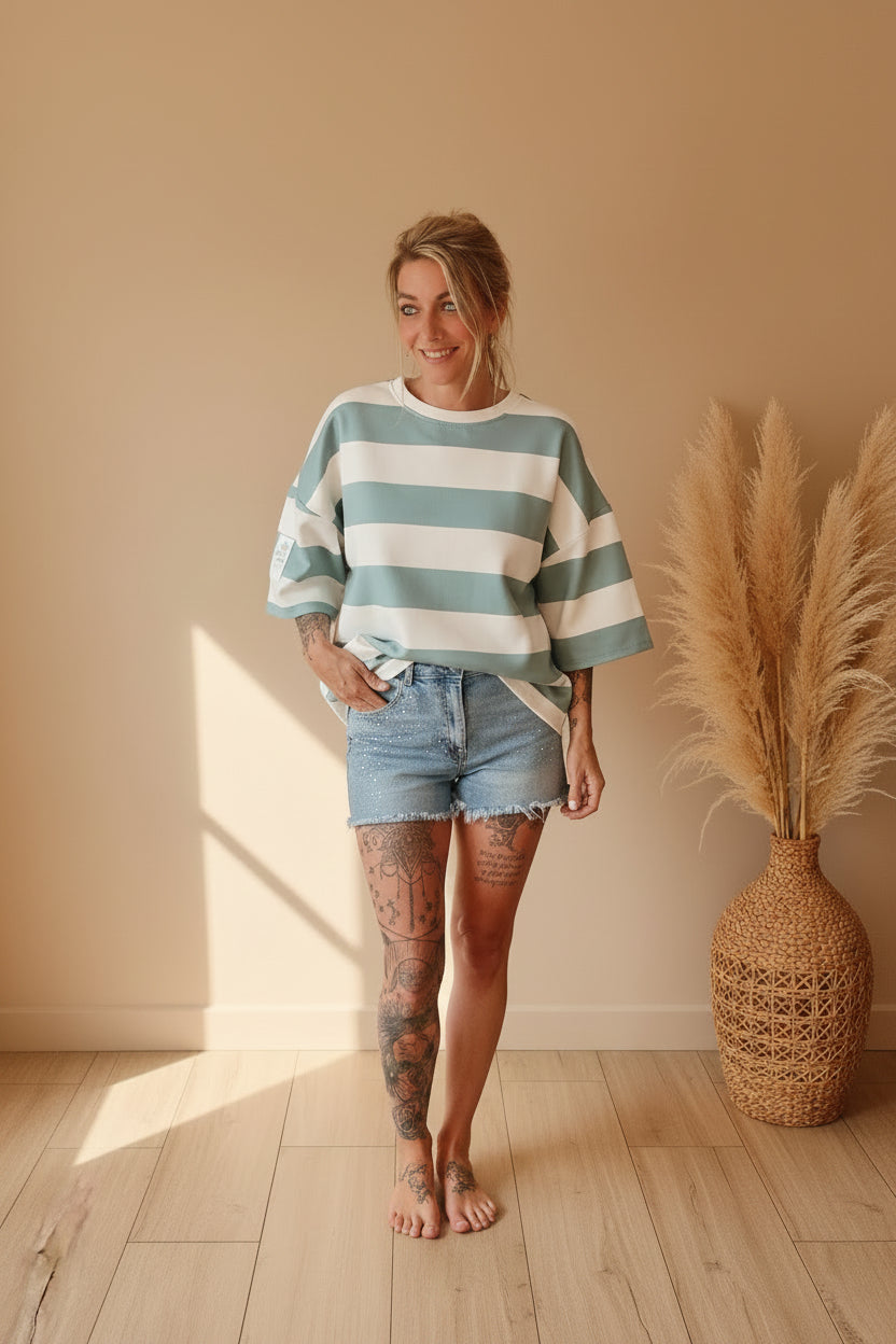 Boho-Luxe Look: Weiß-blau gestreiftes Oversize-Shirt aus Baumwolle und Denim-Shorts.