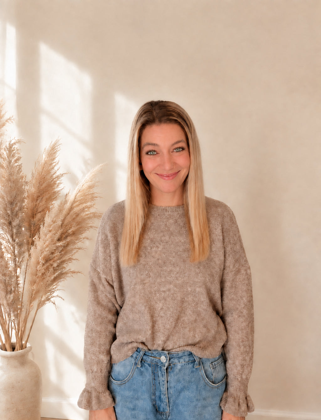 Taupefarbener Damenpullover von vorn am Model, locker zu blauen Jeans getragen.