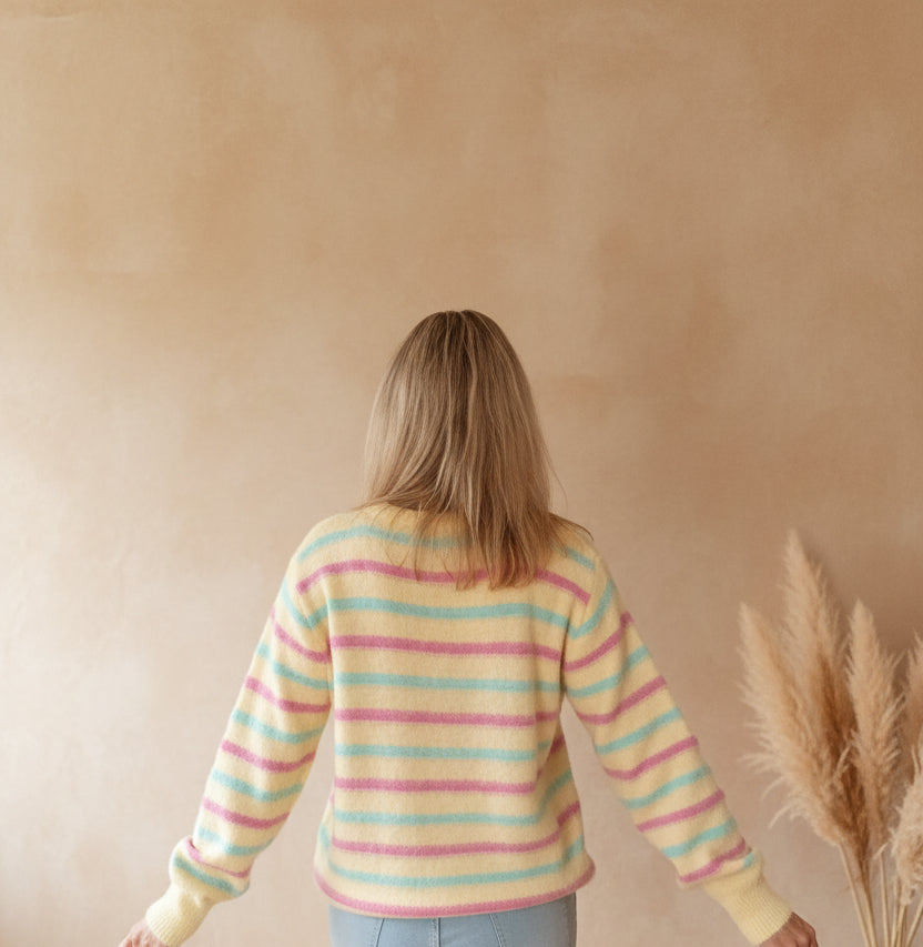 Boho-Luxe gestreifter Damenpullover aus weichem Material in Gelb, Rosa und Türkis.