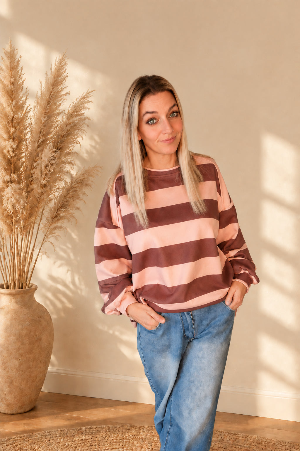 Gestreiftes Damen-Sweatshirt in Rosa und Braun mit lockerem Schnitt, am Model in leicht schräger Vorderansicht.