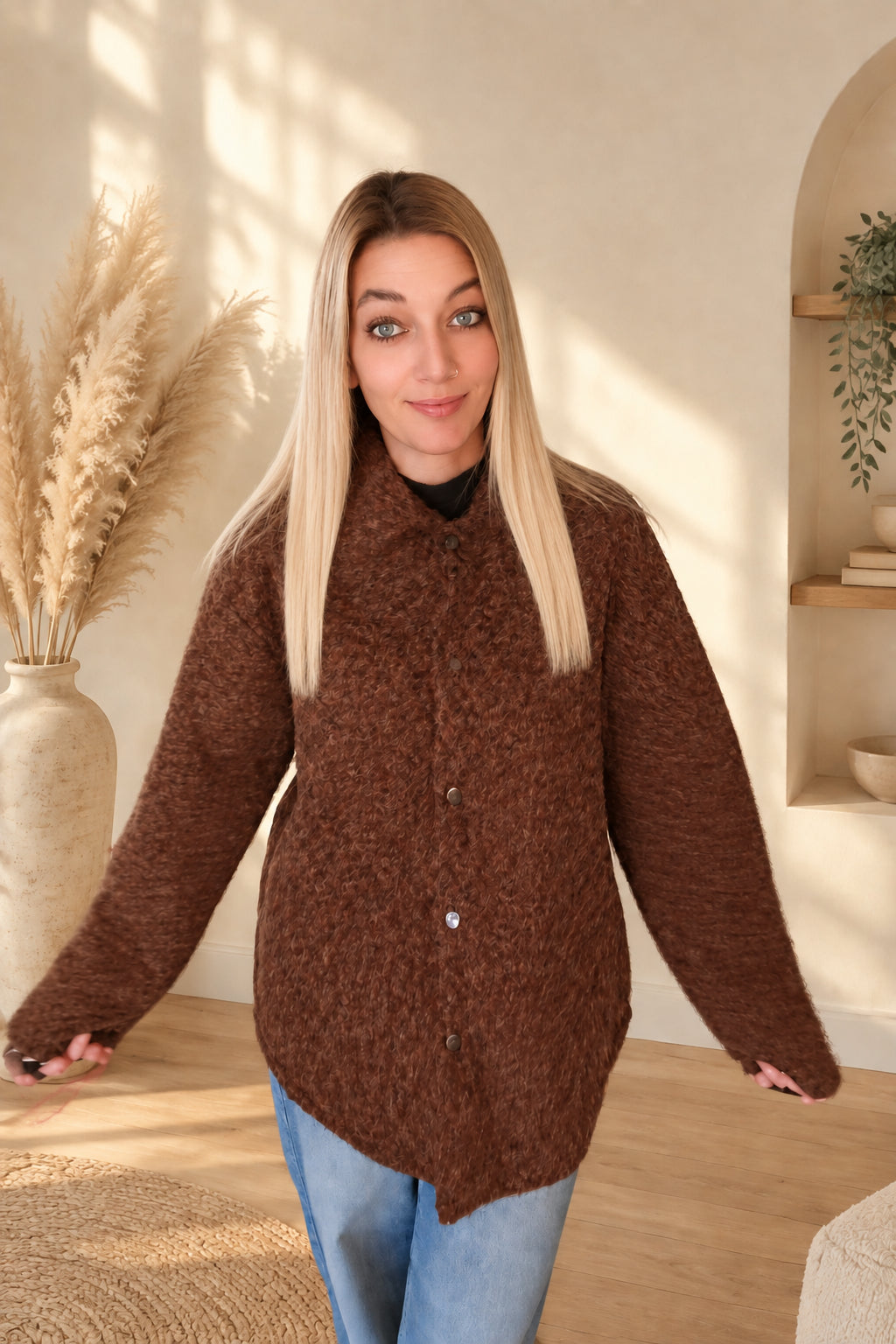 Geschlossene braune Damenjacke mit Kragen und Knopfleiste, am Model mit leicht seitlich ausgestreckten Armen.