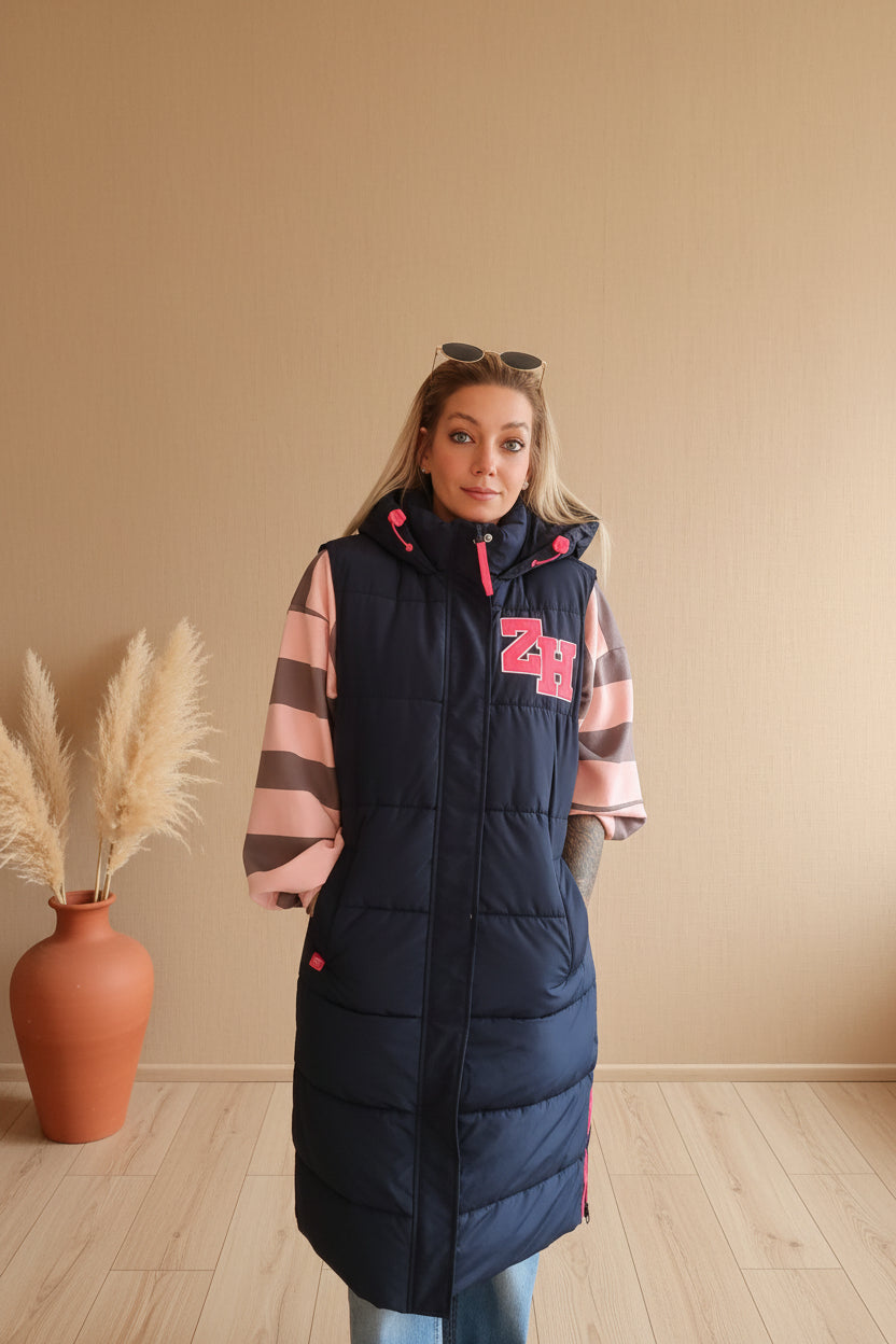 Frau in dunkelblauem gestepptem Boho-Luxe Mantel mit rosa-grau gestreiften Ärmeln.