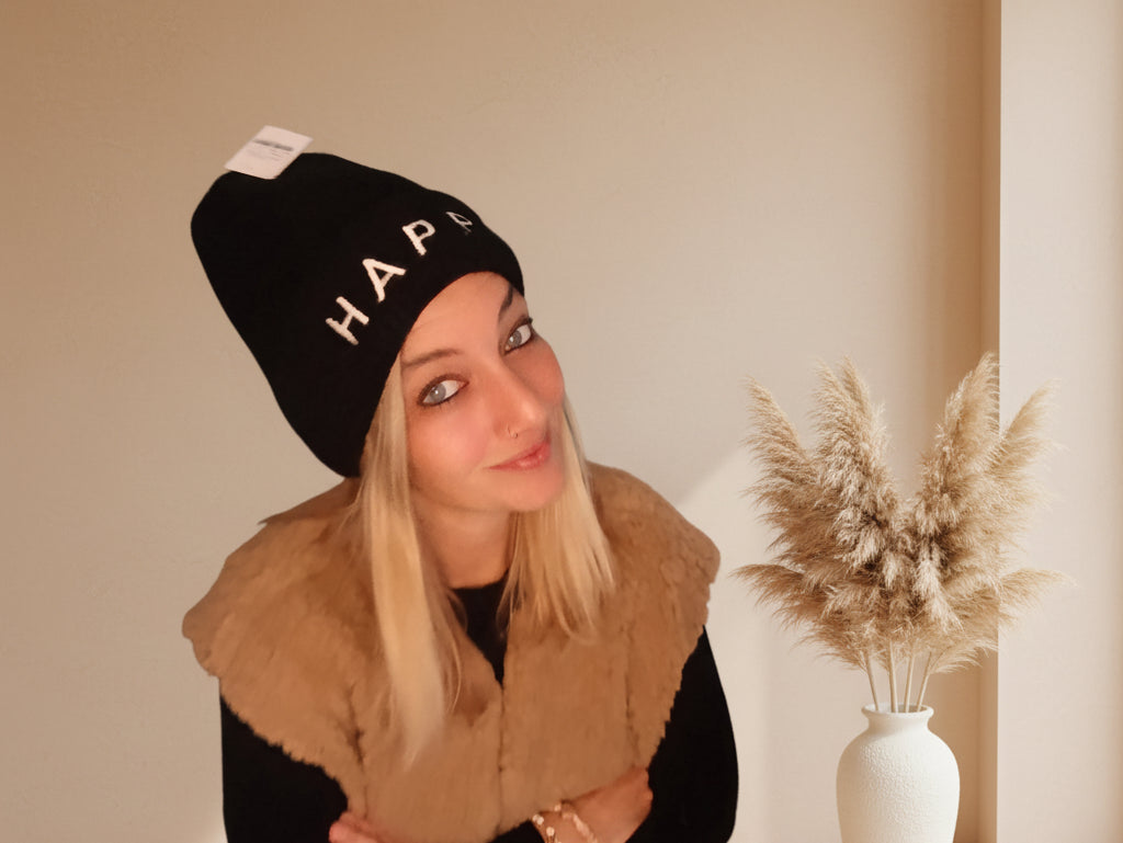 Schwarze Damen-Strickmütze HAPPY in Seitenansicht mit hellem Schriftzug und gerippter Struktur