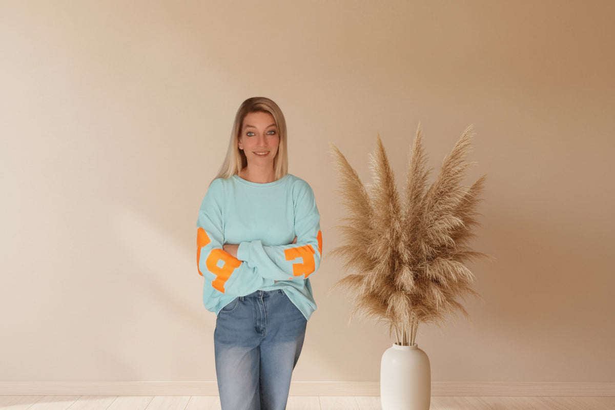 Frau im hellblauen PARADISE Sweatshirt von SK-Style & Kompetenz aus weichem Material im Boho-Luxe Stil