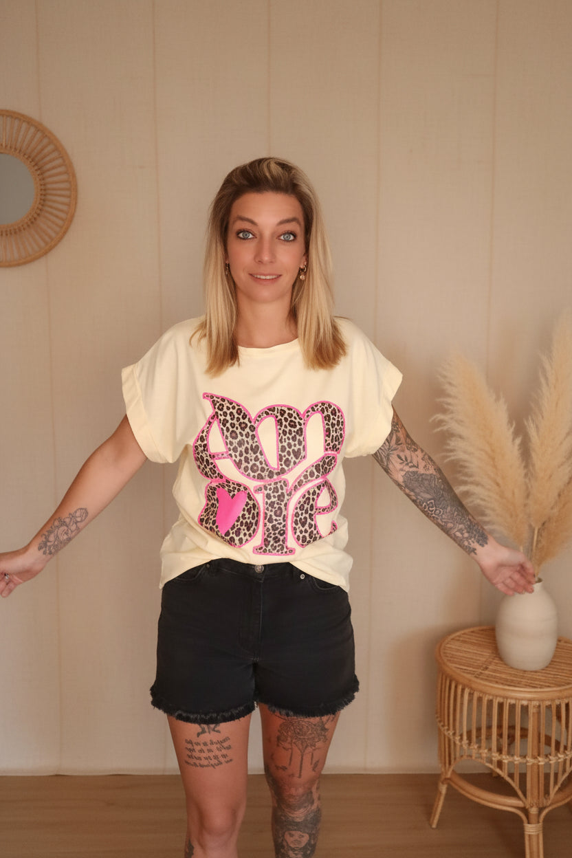 AMORE Leo Cuffed Tee Gelb – Frontansicht mit großem Amore-Schriftzug im Leo-Muster, Gr. S/M