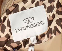 Zwillingsherz Steppmantel Leo AOP Beige – Detailansicht Reißverschluss und Innenfutter