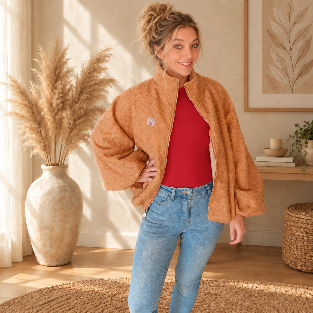Karamellbraune Damen-Teddyjacke mit Kragen und weiten Ärmeln, offen zur Jeans getragen