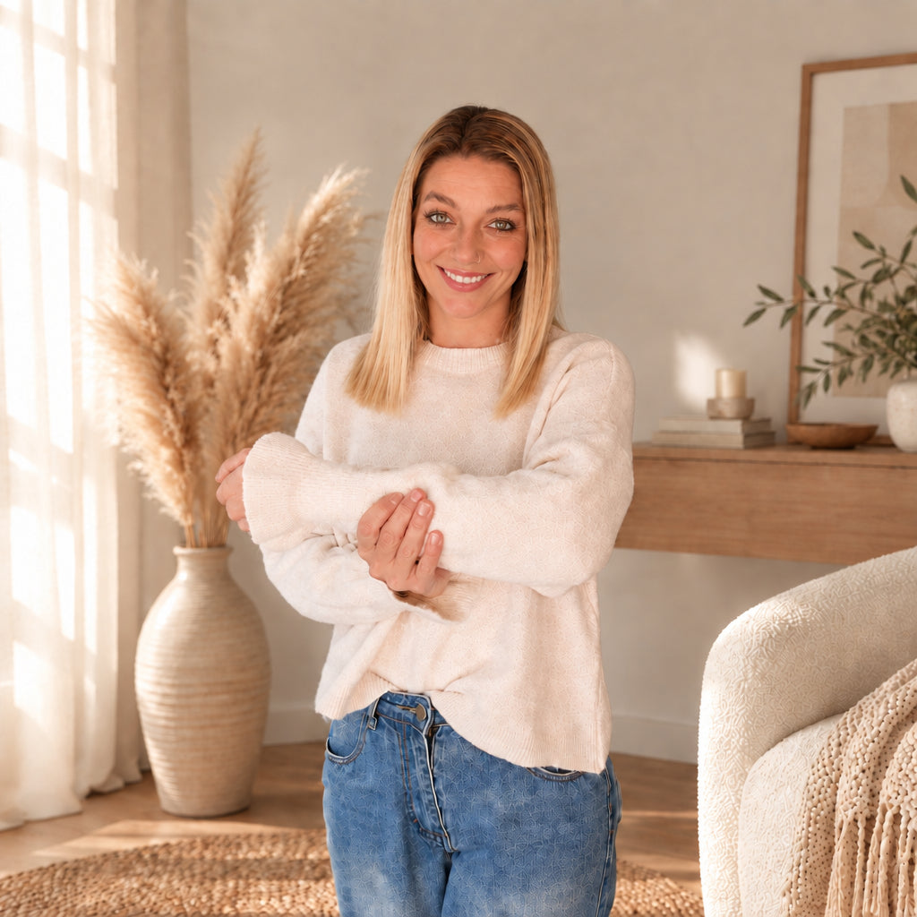 Heller Damenpullover am Model, mit nach vorn gehaltenen Armen und sichtbaren Ärmelabschlüssen.