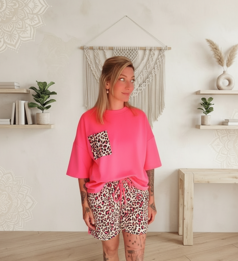 Boho-Luxe Outfit: Pinkes Oversize-Shirt mit Leopardenprint-Tasche und passenden Shorts.