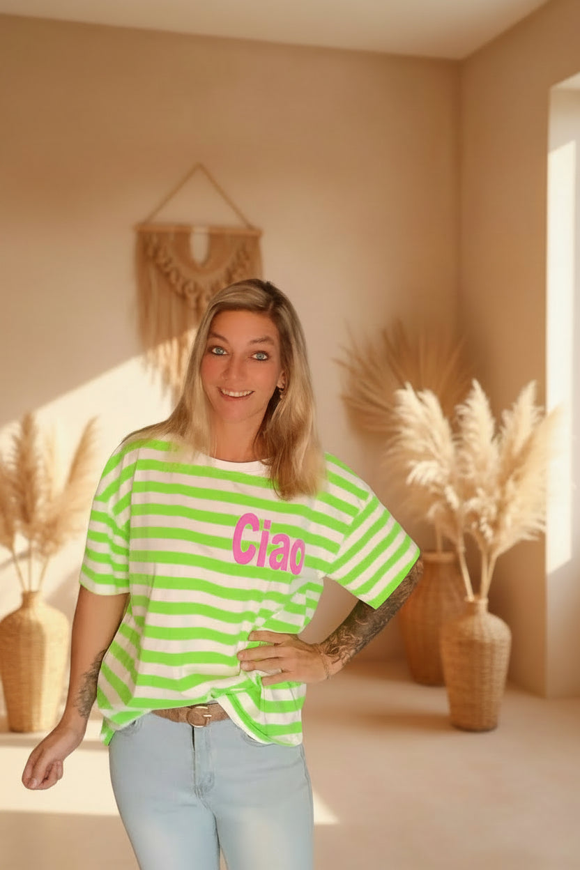 Boho-Luxe Look: Frau in grün-weiß gestreiftem Baumwoll-T-Shirt mit pinkem Ciao-Schriftzug.