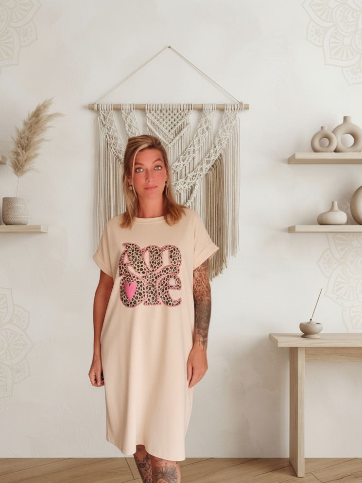 Boho-Luxe Damenkleid aus beigem Jersey mit pinkem Leopardenprint-Schriftzug.