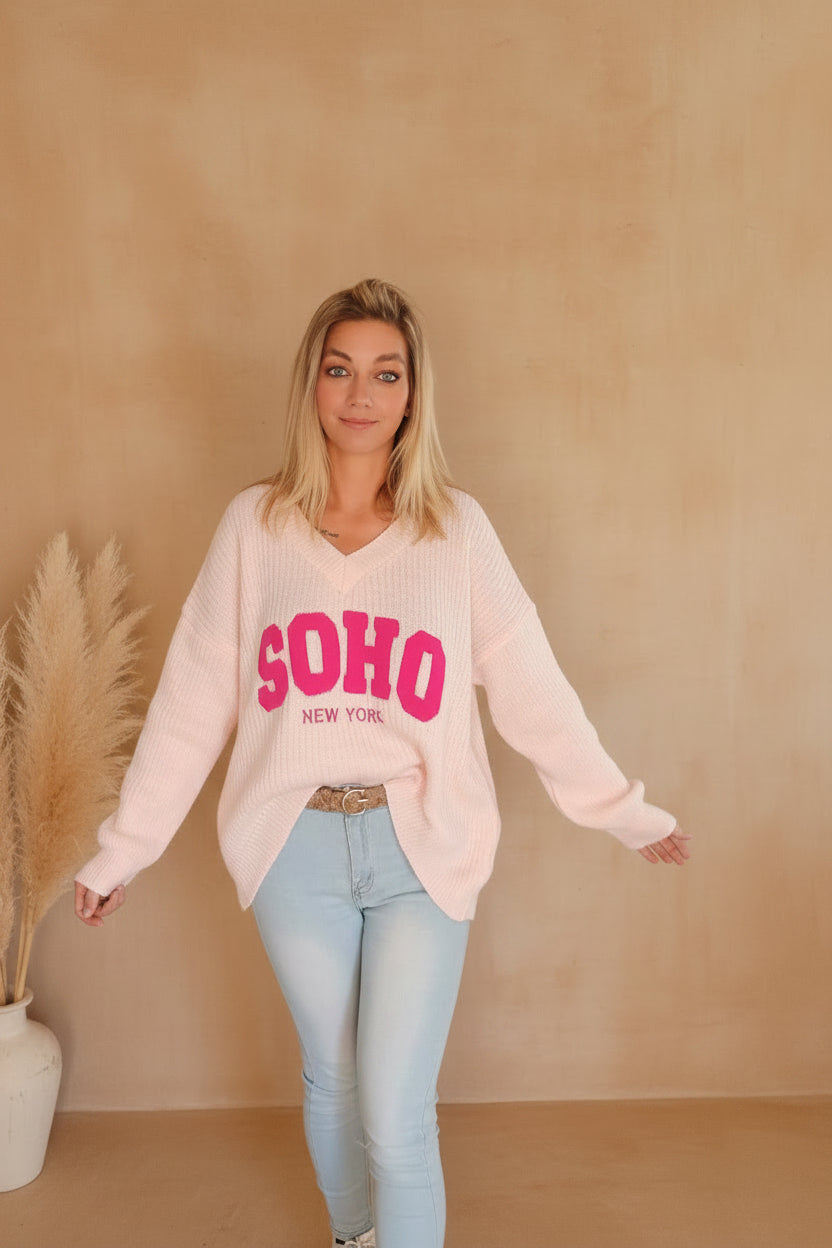 SOHO New York Strickpullover Rosa – Frontansicht mit pinkem SOHO-Print, V-Ausschnitt, Sonnenlicht
