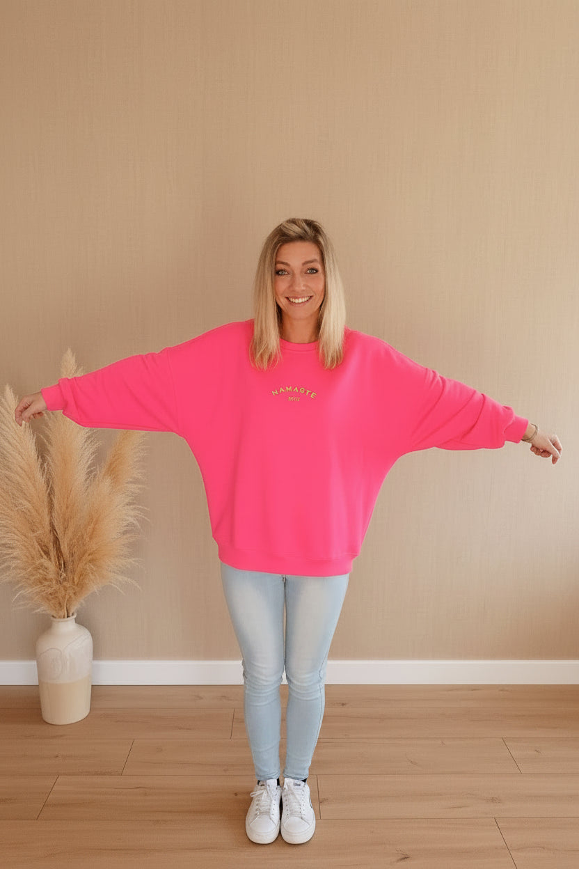 Namaste 24/7 Oversized Sweatshirt Pink – Frontansicht mit goldenem Namaste-Logo, Pampas-Deko

