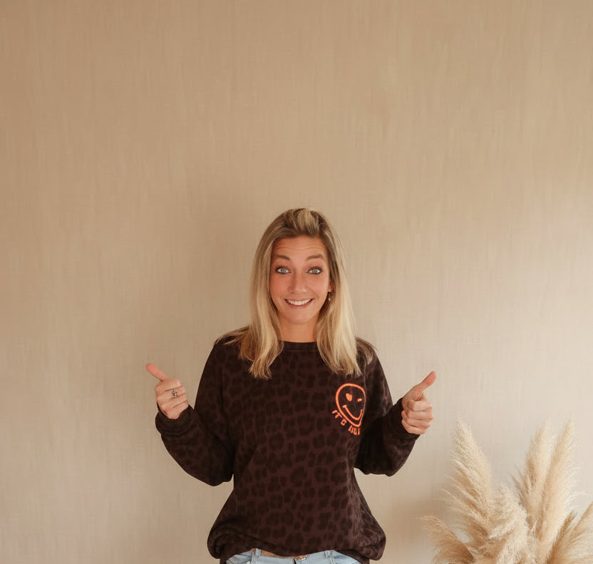 Oversized Sweater Leo-Print – Frontansicht Daumen hoch lächelnd, Smiley-Logo Brust, Pampas Vase Sandton