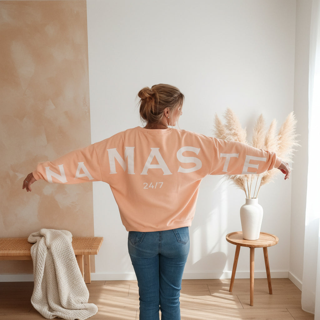 Rückansicht Damen Sweatshirt in Peach mit großem weißem NAMASTE-Print und 24/7-Schriftzug