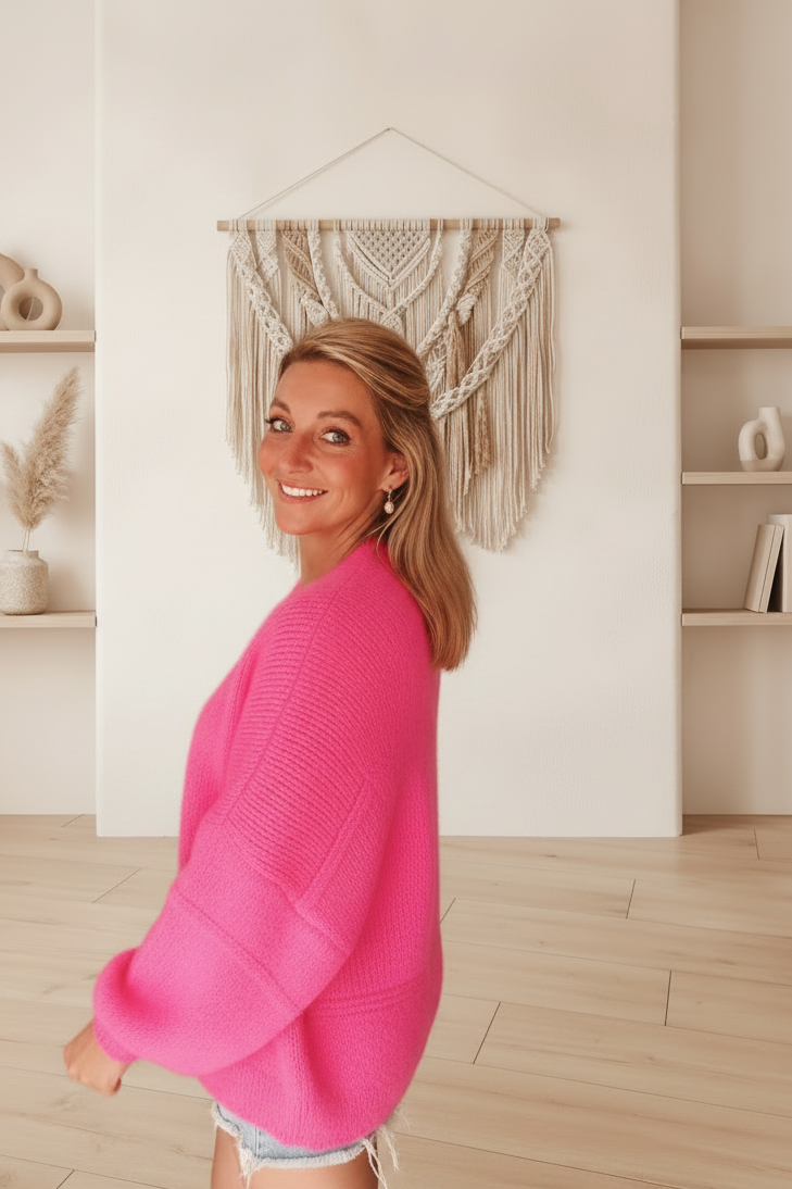 Boho-Luxe Damenstrickjacke in leuchtendem Pink, weiches Material, stilvoll kombiniert mit Jeans